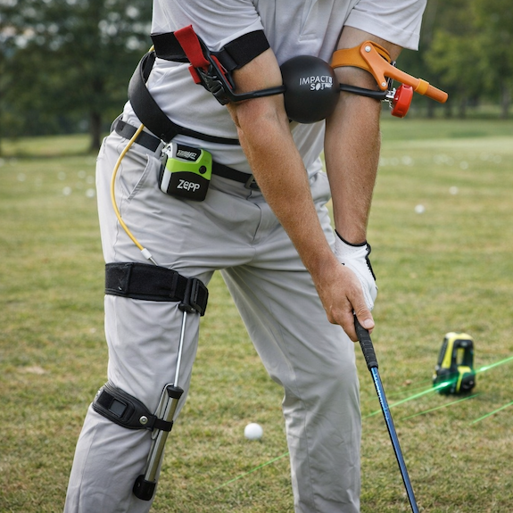 Golfer wearing multiple swing training devices